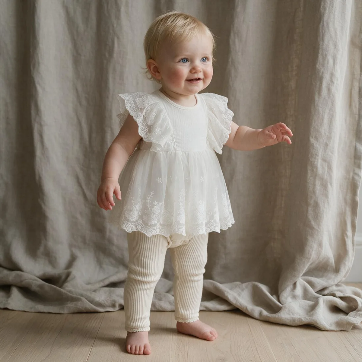 Toddler standing in an ivory dress with an embroidered scalloped moon collar